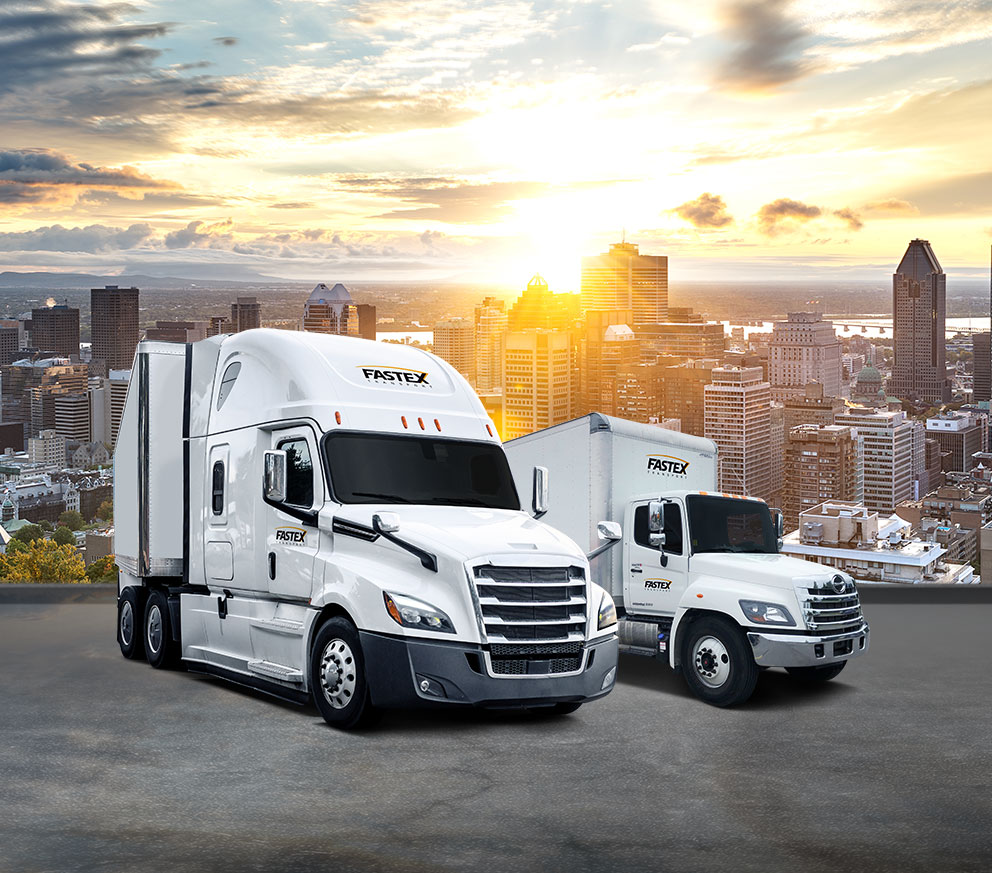 Fastex transport truck and straight truck parked, with city of Montreal in the background.