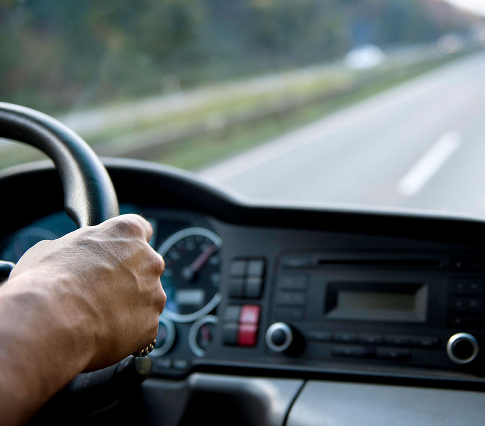 Un conducteur de camion dans une cabine conduisant sur l’autoroute.